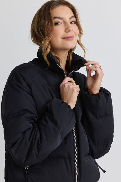 model wears a black puffer jacket