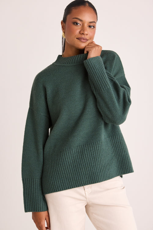 model wears a green knit jumper