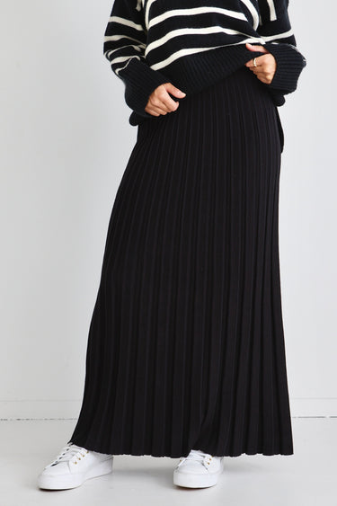 model wears a black knit maxi skirt