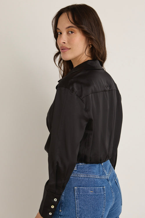 model wears a black shirt and blue jeans