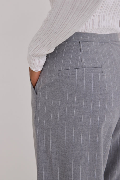 model wears white long sleeve top and grey pinstripe pants