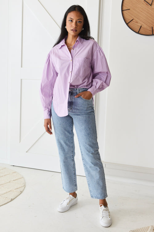 model wears purple button up long sleeve shirt and blue jeans