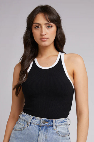 model in black tank with white lining and blue jeans