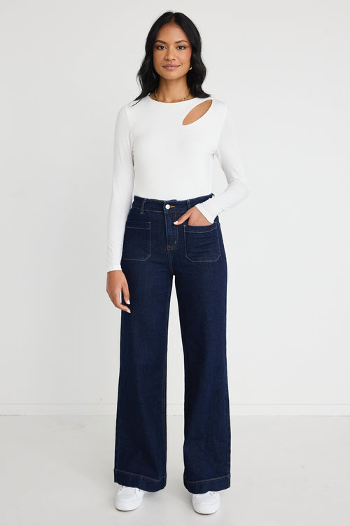 Model wears a white long sleeve top with jeans