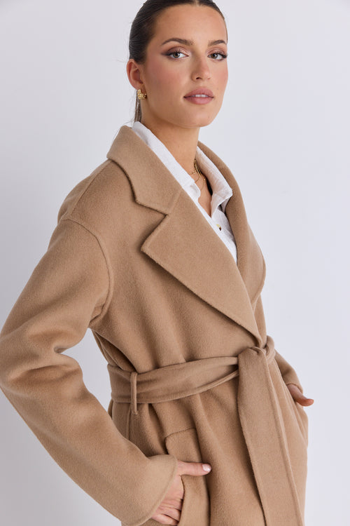 model wears a tan coat