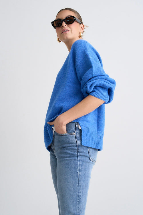 Model wears a blue jumper with jeans