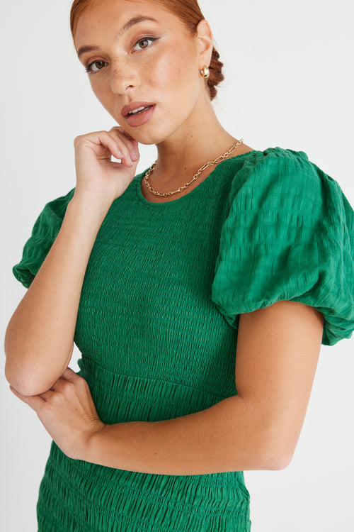 model wears a green midi dress