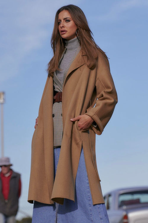 model wears a brown coat 