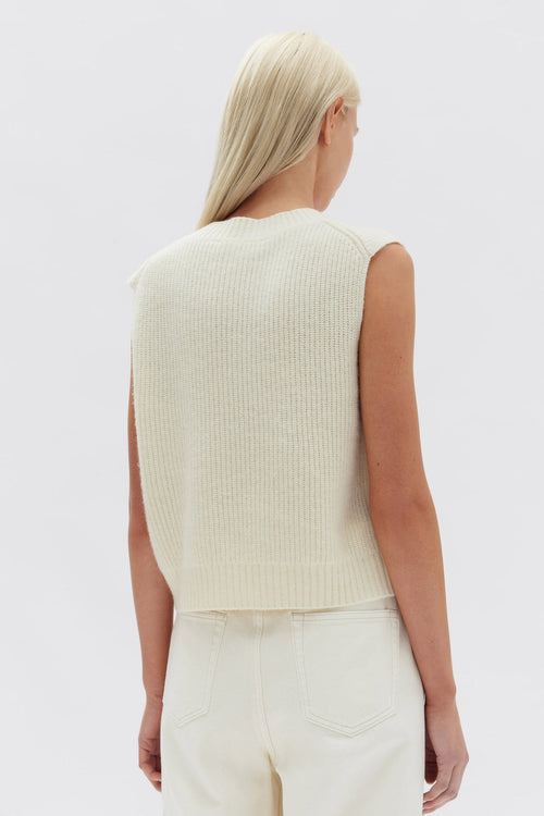 Model wears a white knit vest