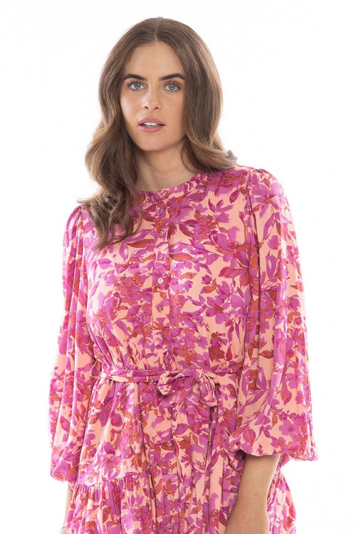 model posing in pink floral long sleeve mini dress