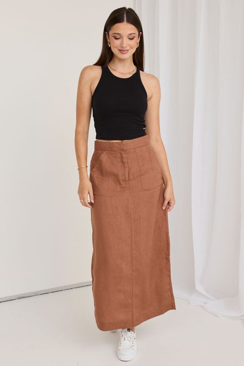 model wears a black tank top and a mocha brown midi skirt with white sneakers