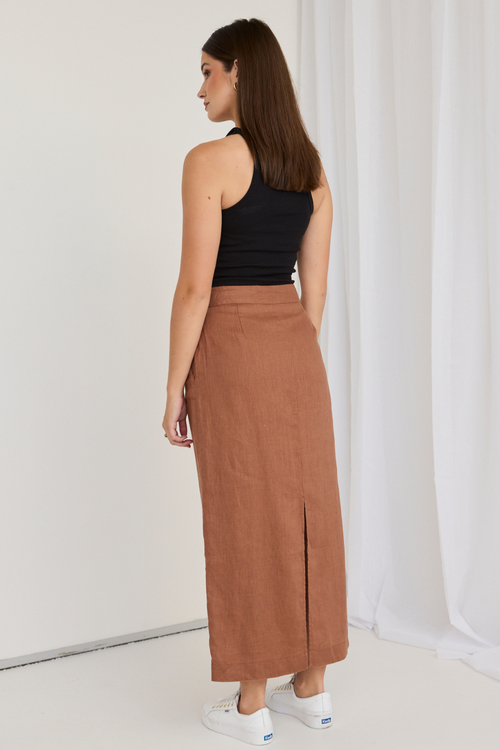 model wears a black tank top and a mocha brown midi skirt with white sneakers