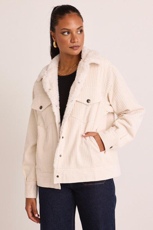 model wears a white cord jacket