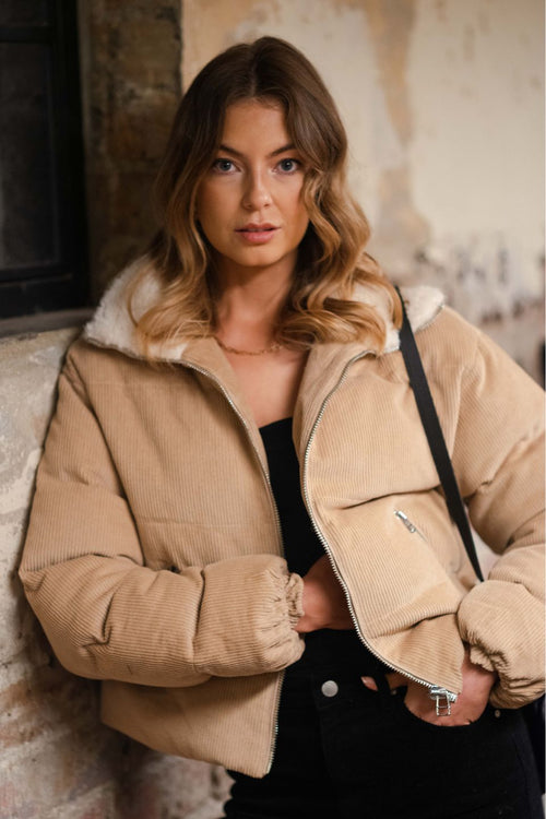 model wears a brown puffer jacket